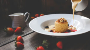 Pouring vanilla sauce on a desert